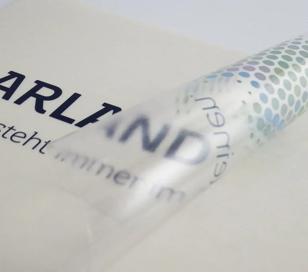 Aufkleber Polymer 2D weiß und transparent – Nahaufnahme einer halb abgezogenen, durchscheinenden Folie mit mehrfarbigem Punktemuster in Wiesbaden von City Medien Einkaufswelt für Partner günstig kaufen, drucken lassen, online preiswert bestellen – Aufkleber, Folien, Sticker