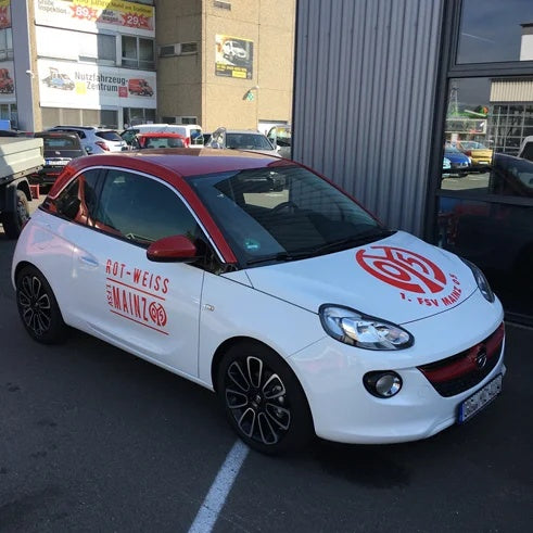 Folienplott Avery 900 – weißer PKW mit rotem Vereinslogo und Schriftzug „Rot-Weiss Mainz“, seitliche Autowerbung in Wiesbaden von City Medien Einkaufswelt für Partner günstig kaufen, drucken lassen, online preiswert bestellen – Folienplott, Autoaufkleber, Fahrzeugwerbung
