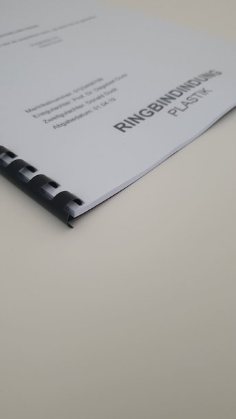 Abschlussarbeit Plastik Spiralbindung 201 bis 400 Seiten: Detailaufnahme des unteren, rechten Teils einer Abschlussarbeit. Das Cover ist weiß, bedruckt und mit einer schwarzen Plastik-Spiralbindung gebunden. Der Text „RINGBINDUNG PLASTIK“ ist am rechten Rand gedruckt, in Wiesbaden bei City Medien Einkaufswelt für Partner