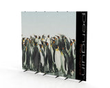CLASSIC penguin: Ein aufgestelltes Werbebanner von vorne. Die bedruckte Oberfläche zeigt eine Gruppe von Pinguinen und einen schwarzen vertikalen Streifen mit dem Schriftzug „penguin the original“. Das Gestell hat gebogene, schwarze Seitenstangen und schwarze Füße, in Wiesbaden bei City Medien Einkaufswelt für Partner