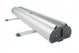 Roll Up Double B 85 cm x H 200 cm: Eine schräge Ansicht der silbernen Roll-Up-Kassette. Sie hat zwei ausklappbare, silberne Füße mit schwarzen Kunststoffenden. Die Enden sind schwarz und mit Schrauben befestigt, in Wiesbaden bei City Medien Einkaufswelt für Partner