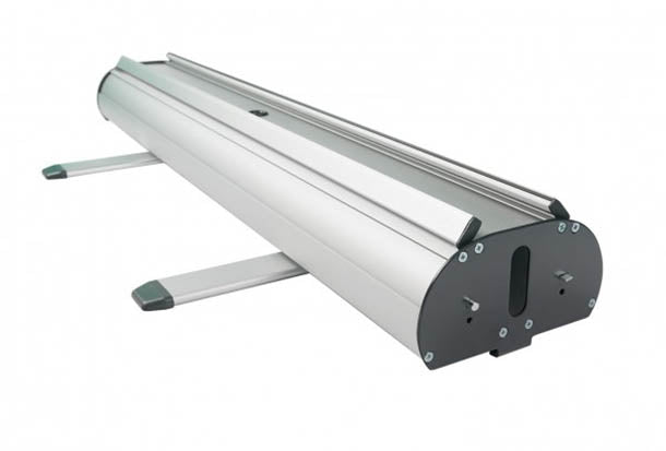 Roll Up Double B 85 cm x H 200 cm: Eine schräge Ansicht der silbernen Roll-Up-Kassette. Sie hat zwei ausklappbare, silberne Füße mit schwarzen Kunststoffenden. Die Enden sind schwarz und mit Schrauben befestigt, in Wiesbaden bei City Medien Einkaufswelt für Partner