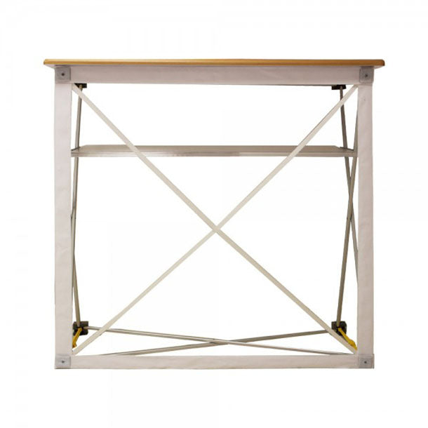 Textilfalttheke B 106 cm x H 102 x T 36 cm: Das aufgestellte, weiße Scherengitter-Gestell von vorne. Es hat eine hellbraune Holzplatte und eine graue Ablagefläche in der Mitte, in Wiesbaden bei City Medien Einkaufswelt für Partner