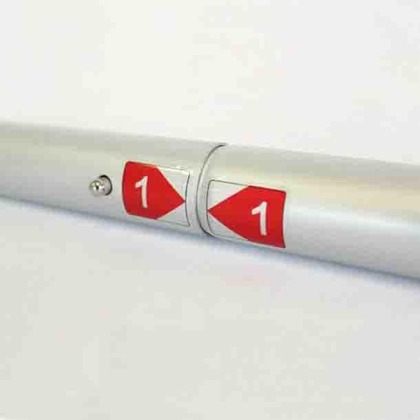 Textilwand ALU gerade gebogen: Nahaufnahme der Verbindung von zwei silbernen, runden Aluminiumstangen. Die Stangen sind mit einem Druckknopf verbunden und haben rote Aufkleber mit der Nummer „1“ und einem Pfeil, in Wiesbaden bei City Medien Einkaufswelt für Partner