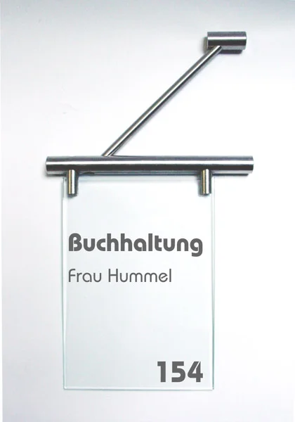Fahnenschild System Seeshaupt: Ein rechteckiges, transparentes Schild mit silbernem Halter. Darauf ist in grau die Zimmernummer der Buchhaltung abgebildet. Das Schild ist hochkant an einer silbernen Halterung an der Wand montiert, in Wiesbaden bei City Medien Einkaufswelt für Partner