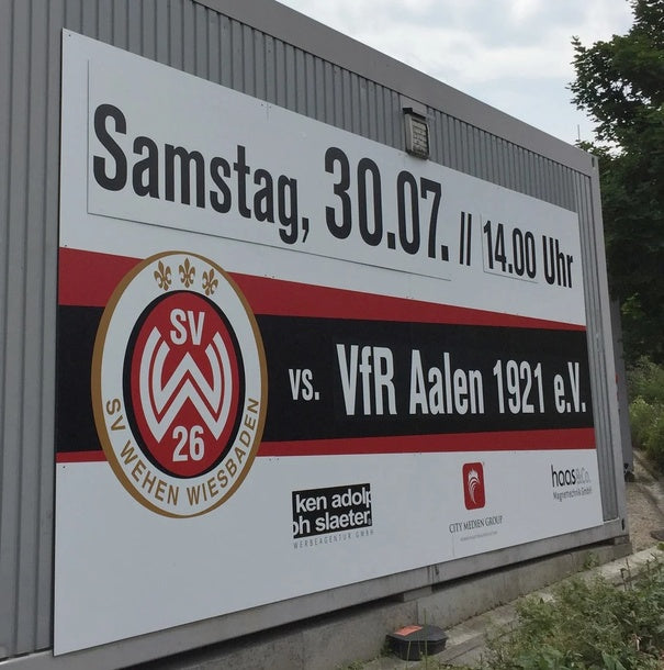 Aluverbundplatte – großflächiges Werbeschild an Gebäudewand, vollfarbig bedruckt mit Vereinslogo und Text in Wiesbaden von City Medien Einkaufswelt für Partner günstig kaufen, drucken lassen, online preiswert bestellen – Bauschilder, Fassadenwerbung, Großformatdruck