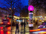 Pinkes Inflatable auf Säule an belebter Kreuzung in der Abenddämmerung – Sonderproduktion für Promotions & Launches, City Medien Einkaufswelt für Partner Wiesbaden – Kategorien: Sonderproduktion, Aufblasbare Werbung – anfragen, produzieren lassen, bestellen
