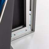 Detailaufnahme einer Rahmen-Ecke, Silberfarbenes Aluminiumprofil mit innerer Nut, Schwarze Textilrückseite teilweise nach vorne geklappt, Eckverbindung mit Metallplatte sichtbar, Mehrere Schrauben und Gewindebolzen zu erkennen, Weiße und graue Rahmenteile liegen sauber ineinander, Bild zeigt die stabile Innenkonstruktion des Textil-Spannrahmens