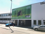Mesh Banner – einseitig bedruckt, großflächiges grünes Werbebanner an Gebäudefassade, luftdurchlässiges Material für langlebigen Außeneinsatz in Wiesbaden von City Medien Einkaufswelt für Partner günstig kaufen, drucken lassen, online preiswert bestellen – Mesh Banner, Fassadenbanner, Outdoor-Werbung