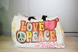 Tragetasche mit Druck – große weiße Stofftasche mit buntem Motiv „Love & Peace“, Herz- und Peace-Symbol, schwarze Henkel, Frontansicht in Wiesbaden von City Medien Einkaufswelt für Partner günstig kaufen, drucken lassen, online preiswert bestellen – Tragetaschen, Werbetaschen, Stoffbeutel